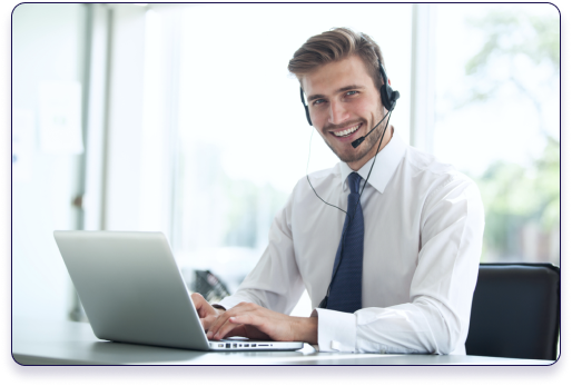 A smiling business professional wearing a headset while working on a laptop
